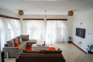 a living room with a couch and a table at Ocean Cliff Homes 4 bedroom shared apartment in Mombasa