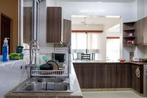 a kitchen with a sink and a dish rack at Ocean Cliff Homes 4 bedroom shared apartment in Mombasa