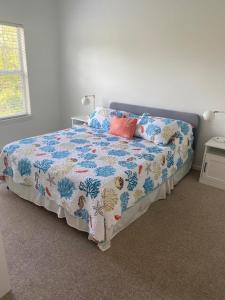 een slaapkamer met een bed met een bloemdekbed bij Coastal Condo with pool, minutes from beach in Saint Simons Island +15 foto's