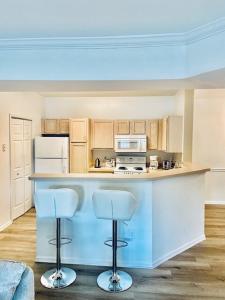 een keuken met een aanrecht en twee barkrukken bij Coastal Condo with pool, minutes from beach in Saint Simons Island
