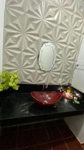 a bathroom with a red sink on a black counter at HOTEL FAZENDA ARIZONA -proximo peruaçu in Januária