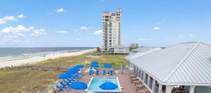 una piscina con ombrelloni e sedie blu accanto alla spiaggia di Dragonfly Dunes a Perdido Key Altre 13 foto