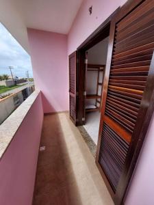 a room with a pink wall and a door at Flat Beira Mar in Ilha Comprida