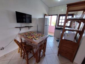 a kitchen with a table and chairs and a refrigerator at Flat Beira Mar Bermudas in Ilha Comprida