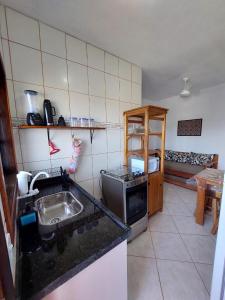 a kitchen with a sink and a stove top oven at Flat Beira Mar in Ilha Comprida