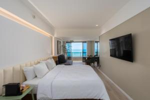 ein Hotelzimmer mit einem Bett und einem Fernseher in der Unterkunft Urban - Beira Mar Boa Viagem in Recife