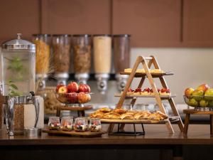 a table with two plates of food and baskets of fruit at Mercure Newcastle in Newcastle
