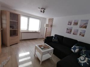 a living room with a black couch and a table at Piratennest in Osteel