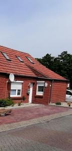 a red brick house with a red roof at Piratennest in Osteel
