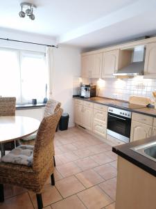 a kitchen with white cabinets and a table and chairs at Piratennest in Osteel