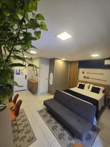 Un dormitorio con una cama y un sofá. en Edf Time - conforto e sofisticação, en Maceió
