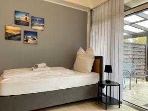 a bedroom with a bed and a balcony at Klein und fein - Terrasse - Stellplatz - WIFI - Star Park  +5 photos