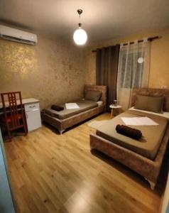 a living room with two beds and a couch at The Guest Apartament 2 bedrooms Fier in Fier