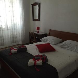 a bedroom with a bed with red and white towels at Apartments Neda in Drače +24 photos