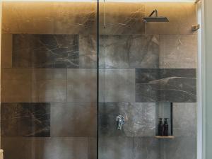une douche dans une salle de bain avec une porte vitrée dans l'établissement Refugio de Lujo en Tulum, à Tulum 23 autres photos
