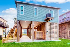 a house with a blue roof and wooden siding at Haven Gulf Views Cargo Lift Large Deck in Crystal Beach