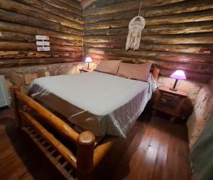 a bedroom with a bed in a log cabin at Cabañas Pampa in Mina Clavero +117 photos