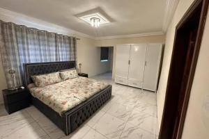 a bedroom with a bed and a dresser in it at 3 Bed Apartment Sleeps 6 - EnSuites Parking Wifi in Freetown