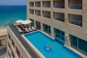 バト・ヤムにあるחדר על הים בבת יםのスイミングプールと海を望むホテルのオーバーヘッドビュー