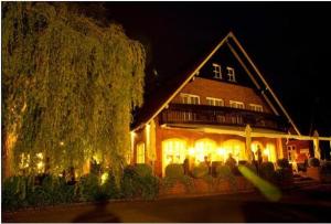 ein großes Haus mit Lichtern in der Nacht davor in der Unterkunft Waldhaus an de Miälkwellen in Ladbergen