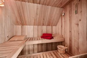 a wooden sauna with a red pillow in it at Rügenzauber Reetdachhaus mit Sauna u Kamin Strandnähe Garten in Dranske