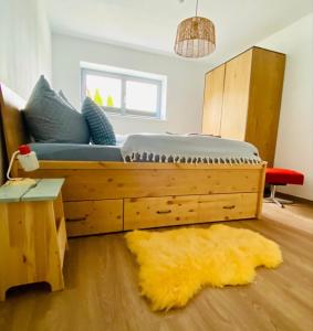 a bedroom with a large wooden bed with a yellow rug at Joe's Home Naumburg -modern,vintage Apartment in Naumburg +22 photos