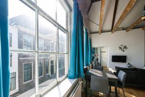 a living room with a table and a large window at Barbera Guesthouse Hotel Apartments - Experience local life in the Old Centre in Haarlem