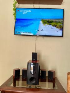 a flat screen tv hanging on a wall with speakers and a table at Hospedaje Fdez Bta En Pedernales in Pedernales +22 photos