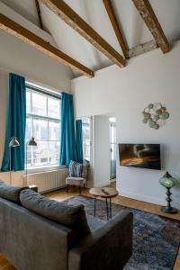 a living room with blue curtains and a couch at Barbera Guesthouse Hotel Apartments - Experience local life in the Old Centre in Haarlem
