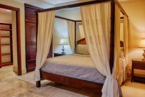 een slaapkamer met een hemelbed en gordijnen bij Beachfront, Sunset, & Ocean Views With Elevator in Tamarindo
