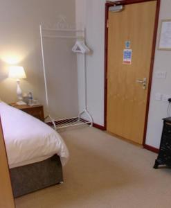 Habitación con cama, puerta y lámpara en The Bridge inn, en Stone 1 foto más
