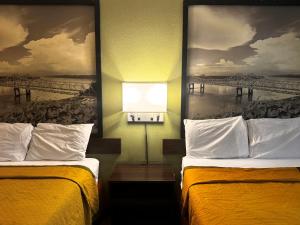 ジャクソンにあるSuper 8 by Wyndham Jackson Ridgelandの橋の絵が飾られたホテルの部屋にはベッドが2つある +39枚の写真
