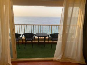 a balcony with a table and chairs and the ocean at APARTMENT PORTO El SOKHNA EGYPT-FAMILY in Ain Sokhna