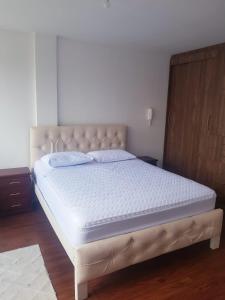 un lit dans une chambre avec un matelas blanc dans l'établissement Acogedora casa moderna, à Quito