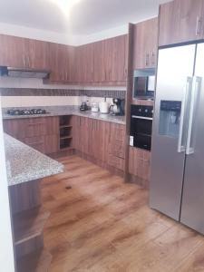 une cuisine avec des armoires en bois et un réfrigérateur blanc dans l'établissement Acogedora casa moderna, à Quito