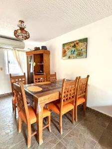 a dining room with a wooden table and chairs at Casa en Ixtapa in Ixtapa