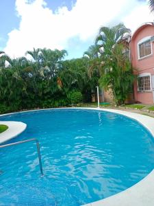 a large blue swimming pool in front of a house at Casa en Ixtapa in Ixtapa