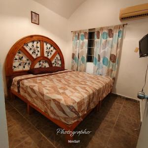a bedroom with a bed with a wooden headboard at Casa en Ixtapa in Ixtapa