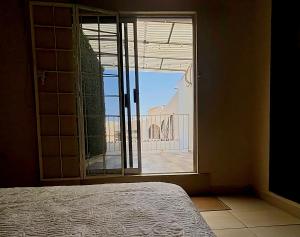 a bedroom with a bed and a window with a view at Habitacion Olmo in Saltillo +5 photos