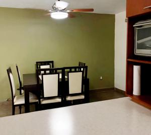 a dining room with a table and chairs and a television at Habitacion Olmo in Saltillo