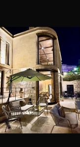 a patio with chairs and an umbrella in front of a building at Very Peri Cappadocia - The Lifestyle Luxury Design Hotel in Uchisar +139 photos