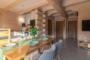 a dining room with a wooden table and chairs at Zielone Wzgórze in Sidzina