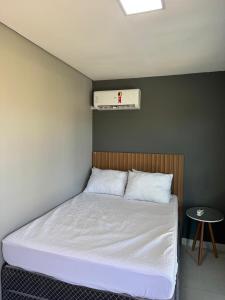 Corumbá 4 - Casa Contêiner com Piscina Aquecida في Alexânia: سرير في غرفة صغيرة مع سرير ابيض +25 صورة