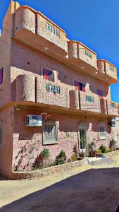 a large brick building with windows on the side of it at Shali Home in Siwa