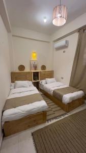 a bedroom with two beds and a chandelier at Shali Home in Siwa +33 photos