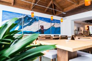 a dining room with a large painting on the wall at Hotel Hoferhaus in Neukirchen am Großvenediger