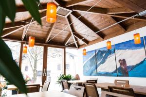 a restaurant with tables and chairs and a large painting on the wall at Hotel-Pension Hoferhaus in Neukirchen am Großvenediger +36 photos