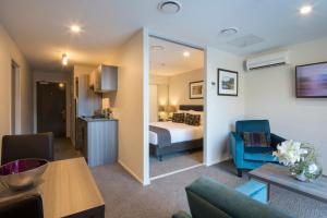 a hotel room with a bed and a living room at Ramada Suites by Wyndham Queenstown Remarkables Park in Queenstown