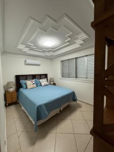 a bedroom with a bed with a blue comforter at Luxury, Charm and Comfort in Guaratuba in Guaratuba