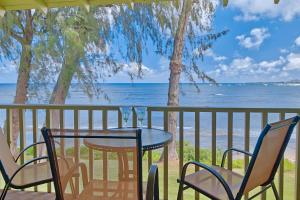 a table and chairs on a balcony overlooking the ocean at Kapa'a Sands 13 in Kapaa